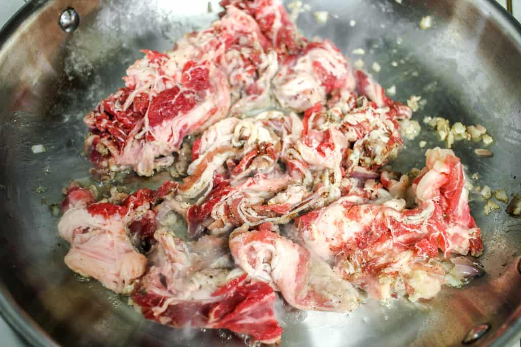 marinated beef cooking in a pan