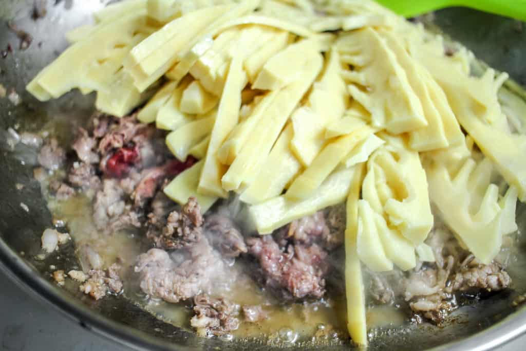 bamboo shoots and beef stir fry cooking in pan