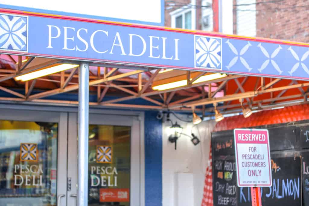 storefront with blue awning that says "pescadeli"