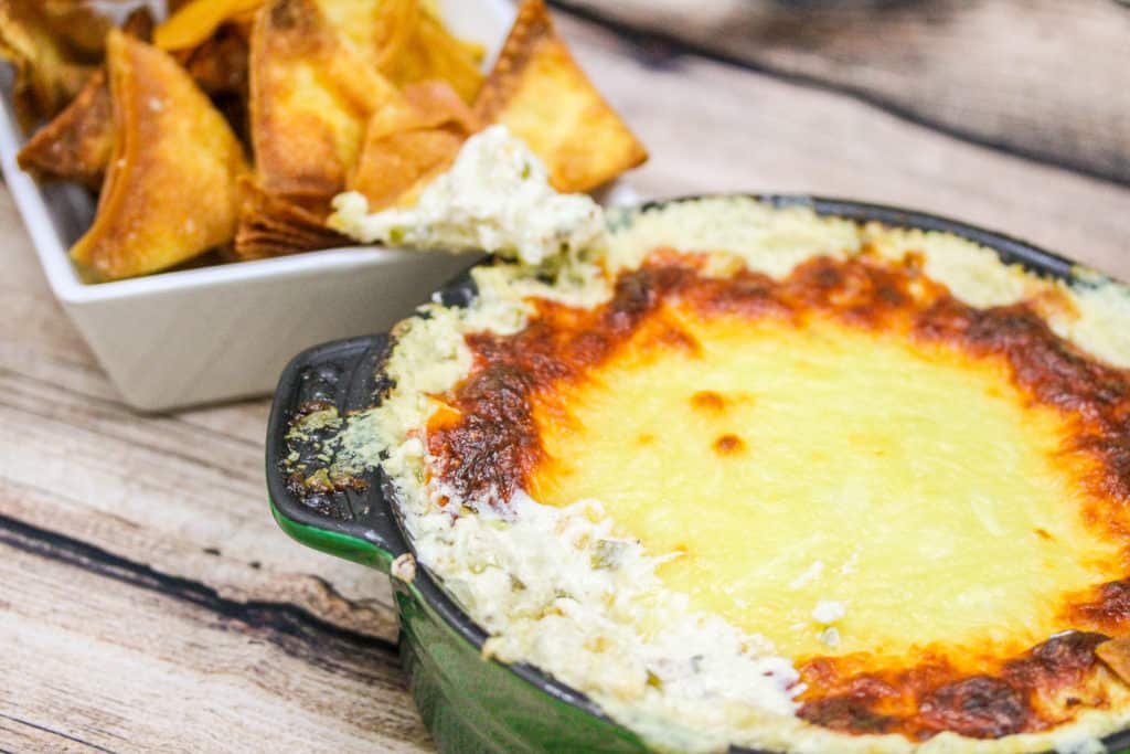 grab rangoon dip in a green pot with wonton chips in a white bowl