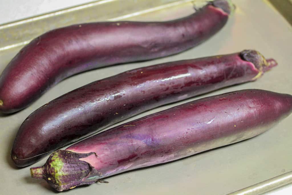 three japanese eggplants on a sheet pan