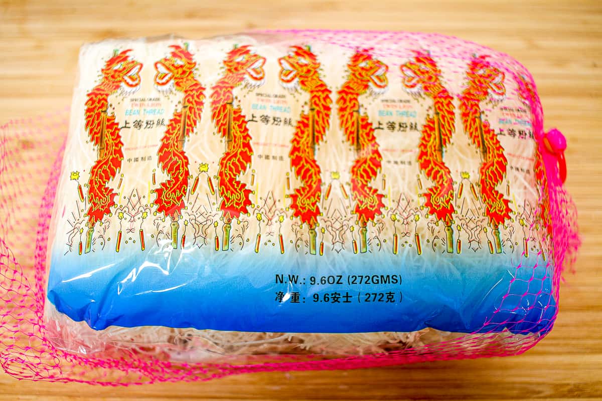 a pink mesh bag filled with thin, dry noodles