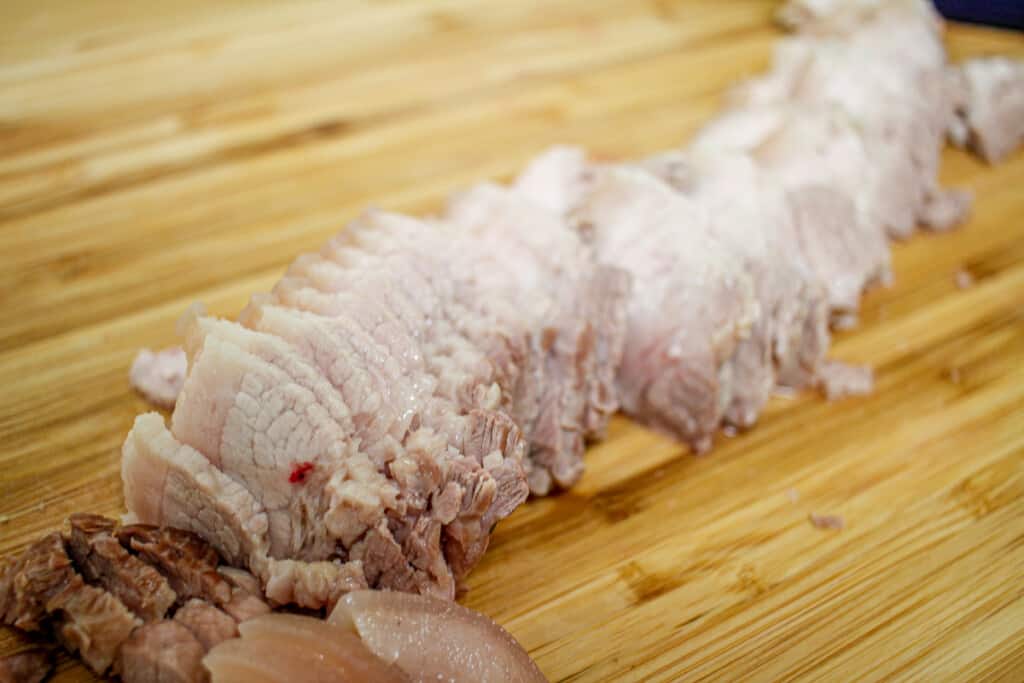sliced pork belly on a wooden board