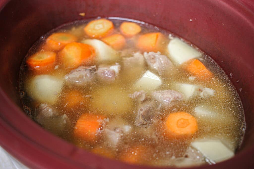 carrots, potatoes and spare ribs in a crock pot filled with water