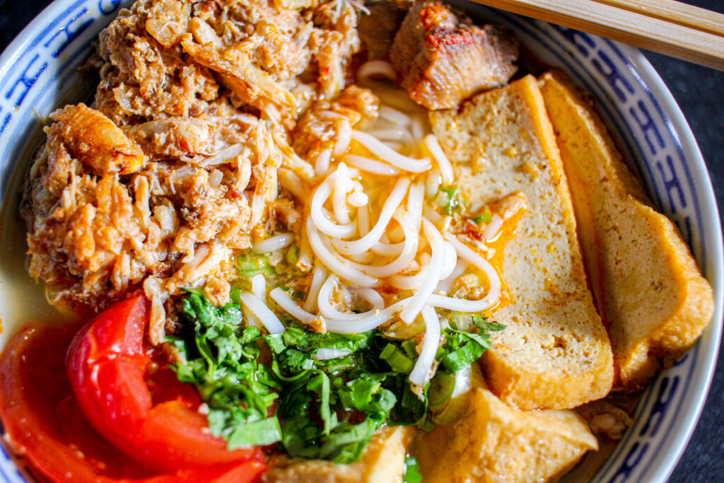 a bowl of bun rieu with cilantro and scallions