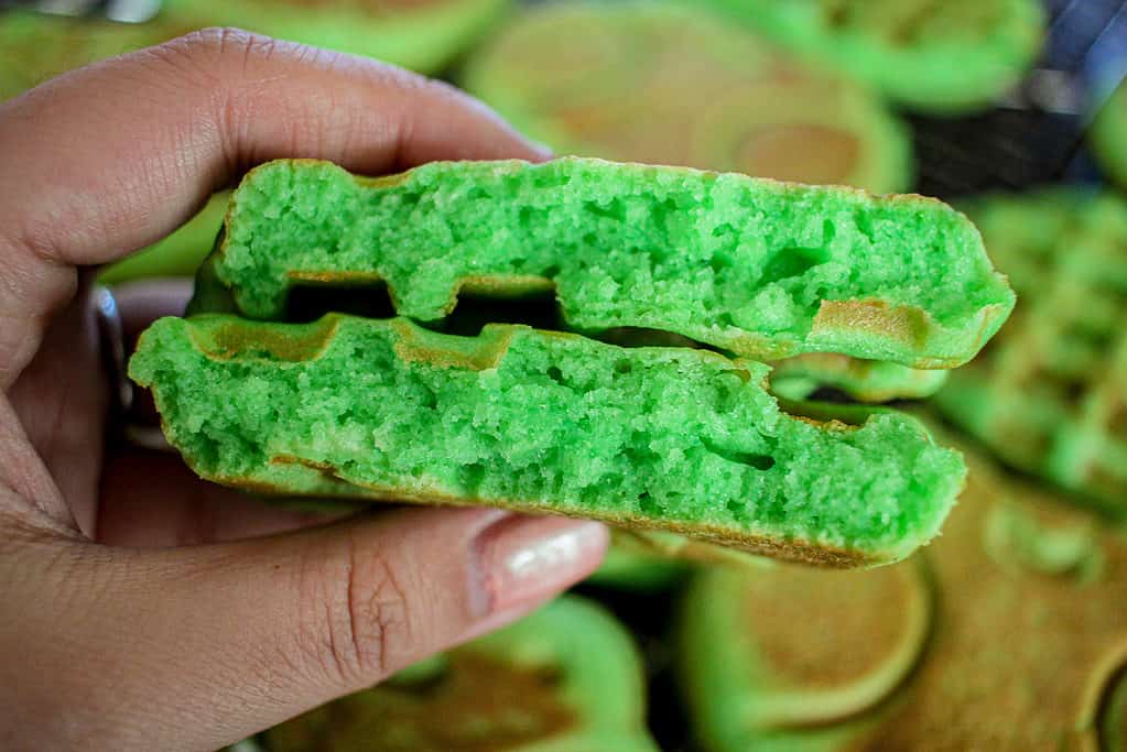 A cross section of a coconut pandan waffle (Bánh Kẹp Lá Dứa) showing the fluffy interior.