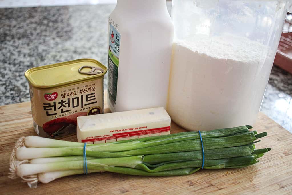 ingredients for spam and scallion biscuits on a wooden cutting board