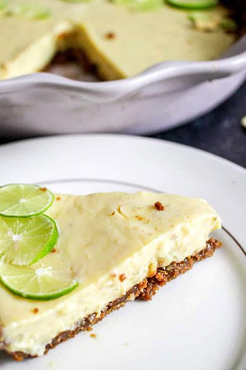 A slice of galangal key lime pie in front of a pie tin.