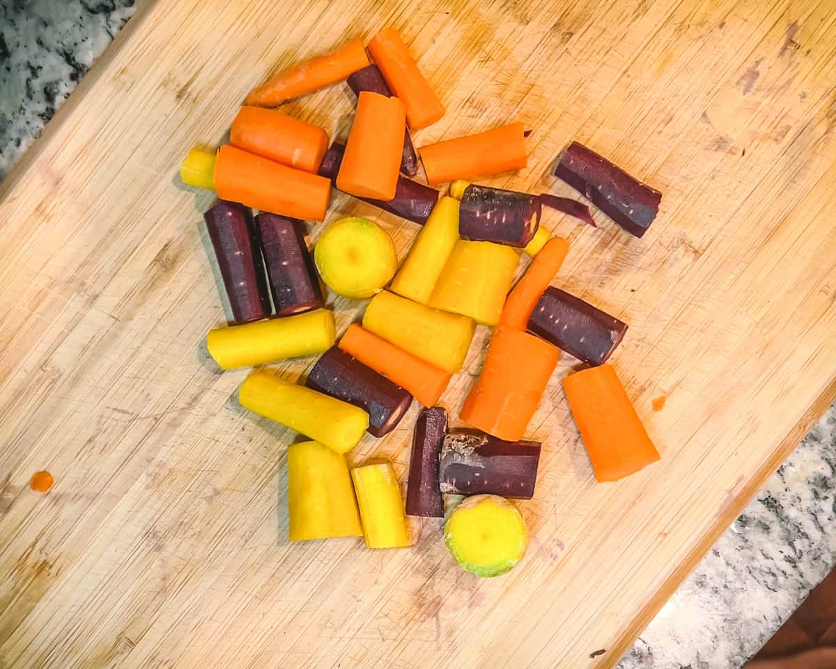 cut up carrots on a wooden cutting board