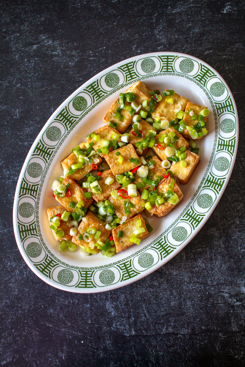 fried tofu with scallions and chili peppers on top, seen from an overhead view